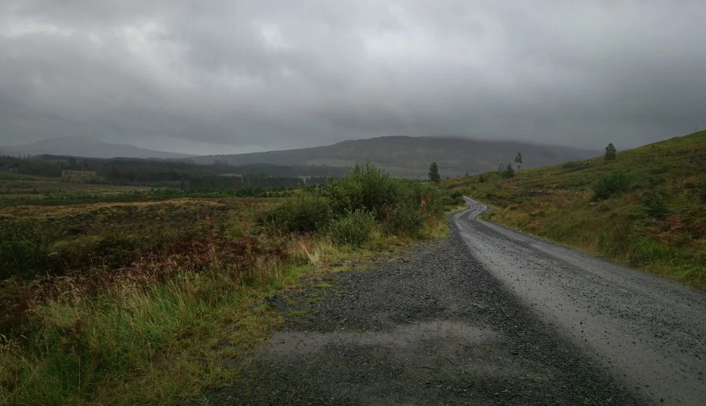 A gravel trail dissapears into the distance under cloudy skies